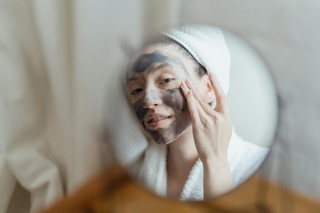 A woman enjoying a beauty routine with a face mask in an indoor setting.
